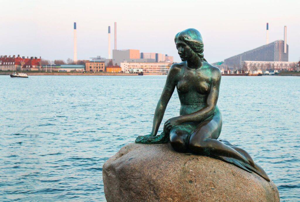 the statue of the little mermaid on a rock in copenhagen denmark